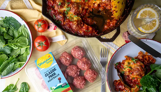 pan of baked meatball and packet of raw meatballs