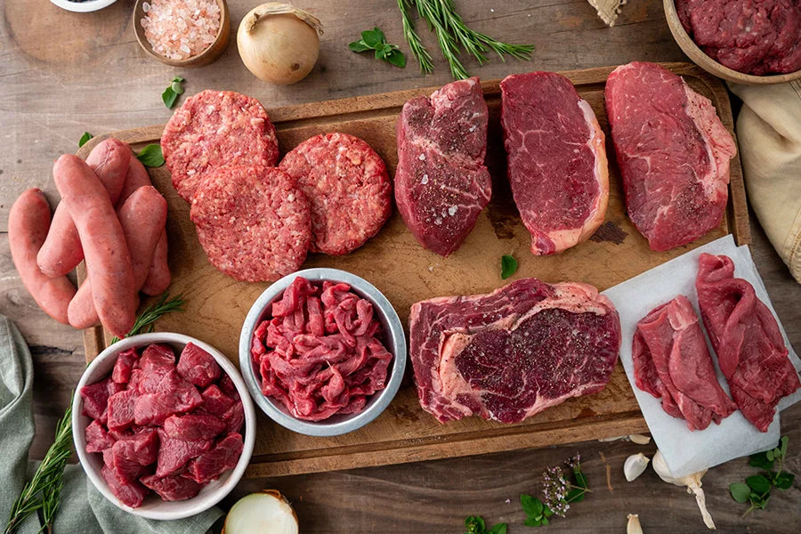 Assortment of raw beef cuts on chopping board