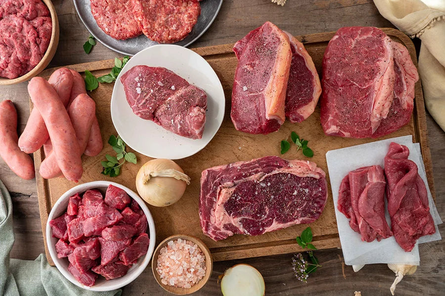 Assortment of raw beef cuts styled on kitchen table