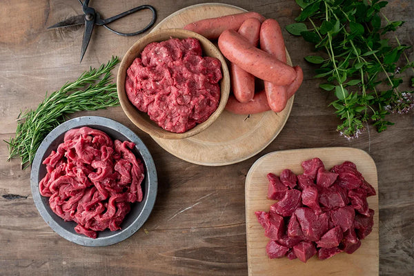 Chopping board with Beef mince, sausages and diced beef plus dish of beef stir fry