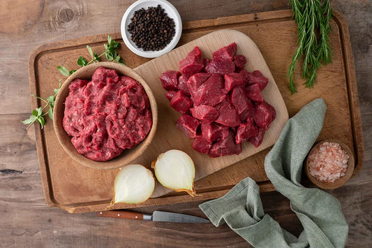 Bowl of Beef Mince and diced beef on chopping board with ramikens of salt and pepper