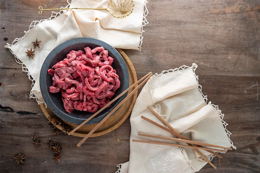 bowl of raw beef stir fry with chopsticks