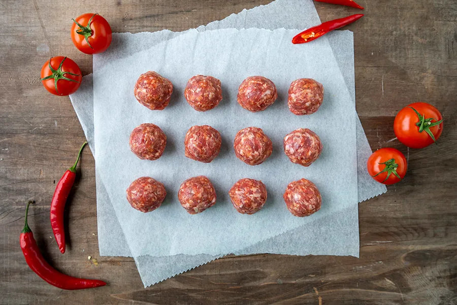 meatballs on bench top with chillis and tomatoes