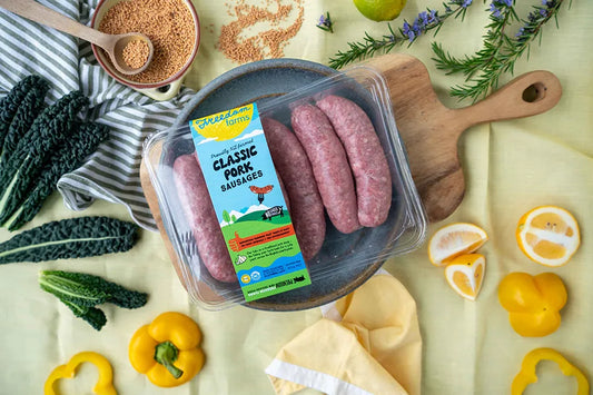 pack of pork sausages on bright table setting