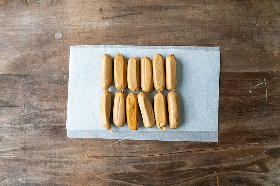 12 junior sausages laid out on kitchen table