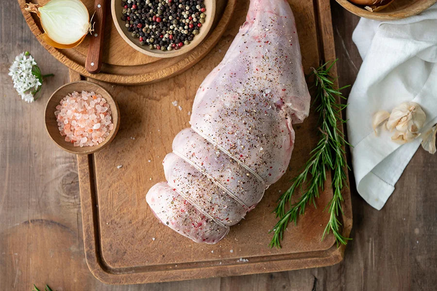 seasoned leg of lamb on chopping board