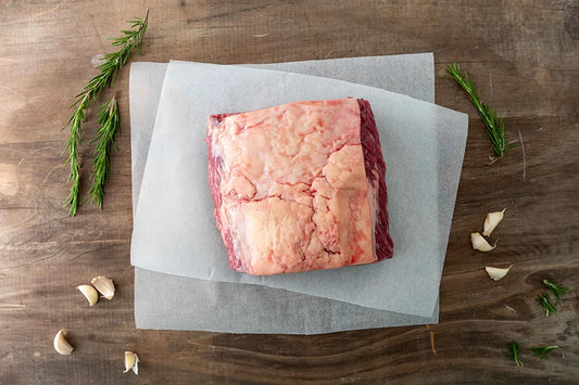 Piece of Beef Rump Roast with fat side up on kitchen table