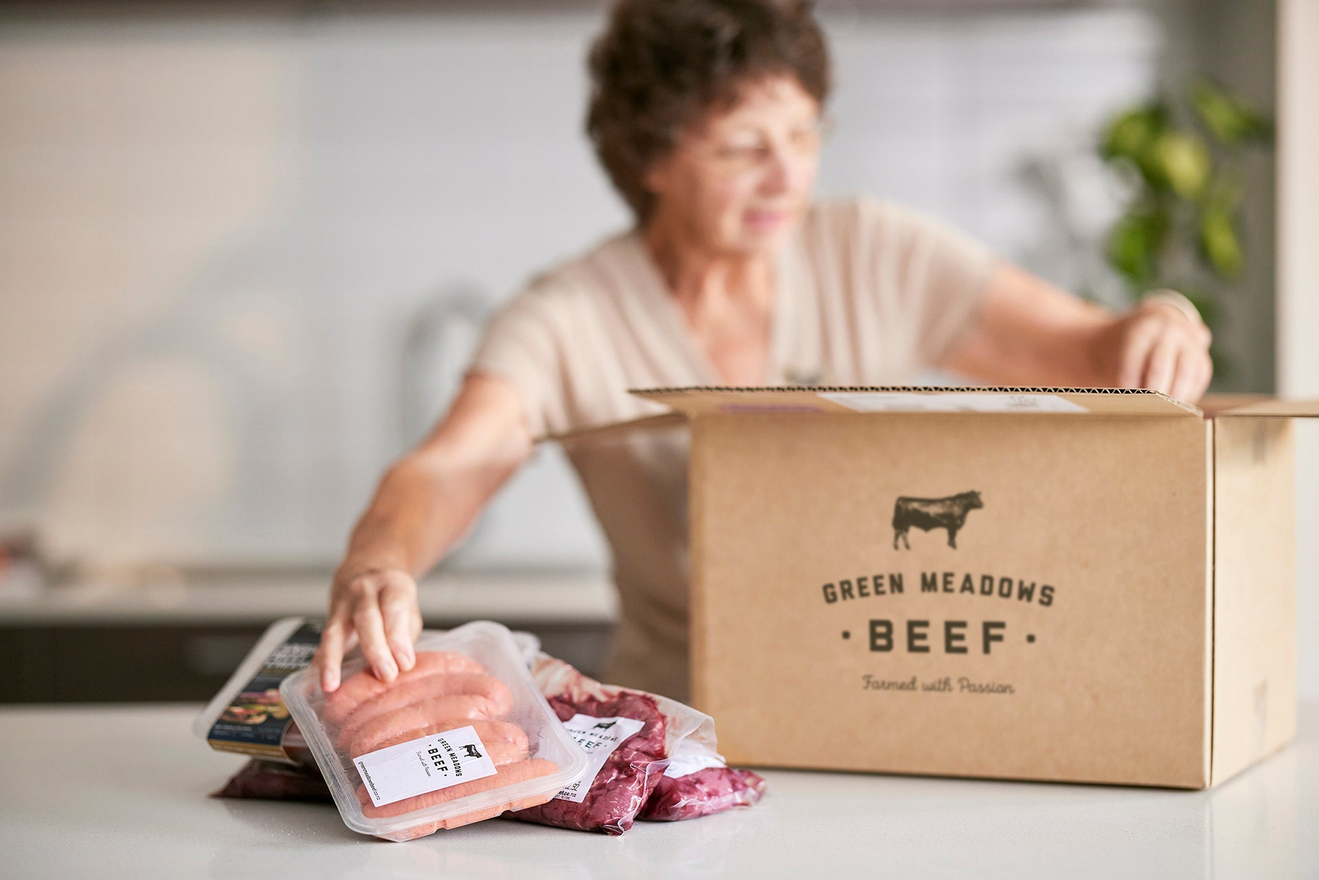 Female unloading beef from meatbox in the kitchen