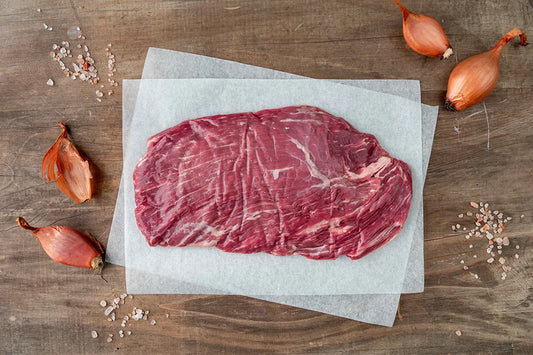 One piece of angus skirt steak on white baking paper