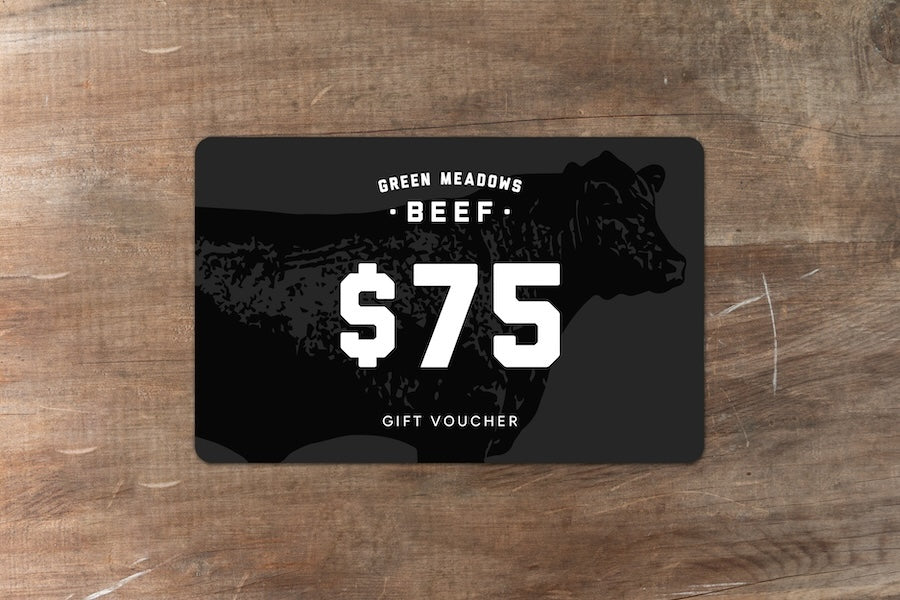 Green Meadows Beef gift voucher for $75 sitting on wood bench